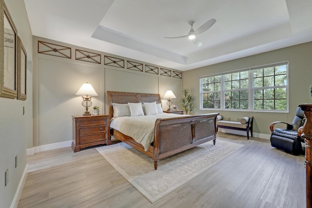 127 Via Castilla, Jupiter, FL 33458 - bedroom with a raised ceiling, light wood-type flooring, baseboards, and a ceiling fan
