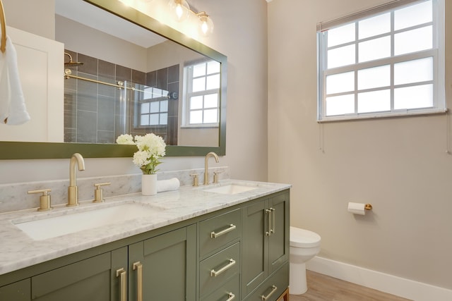 127 Via Castilla, Jupiter, FL 33458 - full bathroom featuring toilet, double vanity, tiled shower, baseboards, and wood finished floors