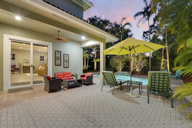 127 Via Castilla, Jupiter, FL 33458 - patio terrace at dusk with outdoor lounge area, an outdoor pool, and a patio