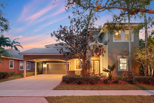 127 Via Castilla, Jupiter, FL 33458 - mediterranean / spanish-style home featuring decorative driveway, stucco siding, an attached garage, and a carport
