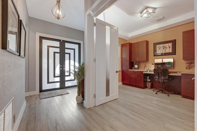 127 Via Castilla, Jupiter, FL 33458 - foyer featuring light wood finished floors, built in study area, baseboards, and french doors