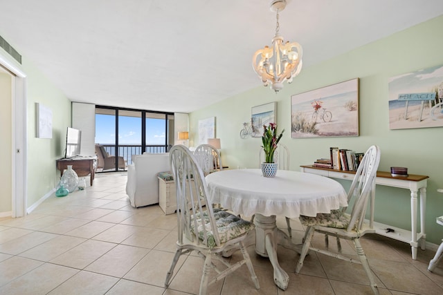 dining space with a chandelier, light tile patterned floors, baseboards, and expansive windows