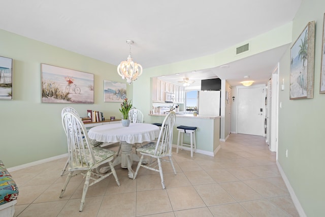 dining area featuring light tile patterned flooring, a chandelier, and baseboards