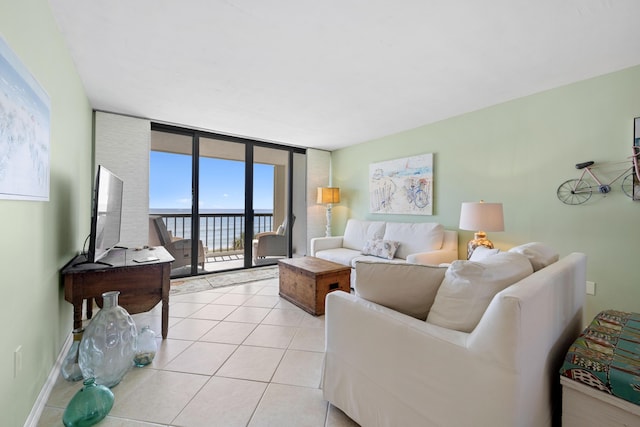 living area with light tile patterned floors, a wall of windows, and baseboards