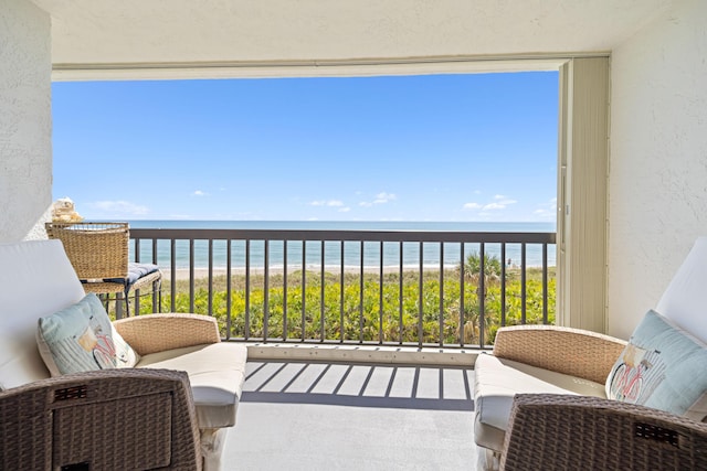 balcony with view of water and beach