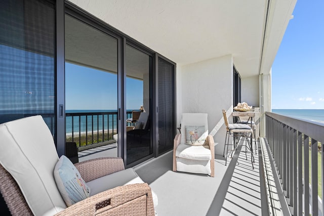 balcony featuring view of water and beach