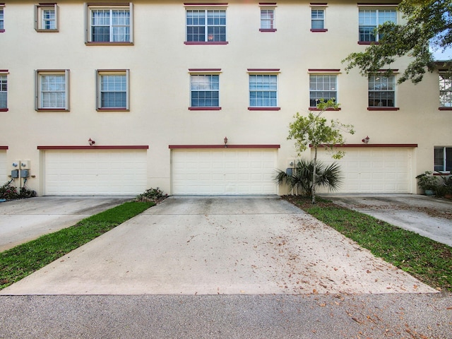 1898 SE Interlachen Dr, Port Saint Lucie, FL 34952 - view of property with stucco siding, an attached garage, and driveway