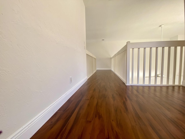 additional living space with dark wood-style floors and baseboards