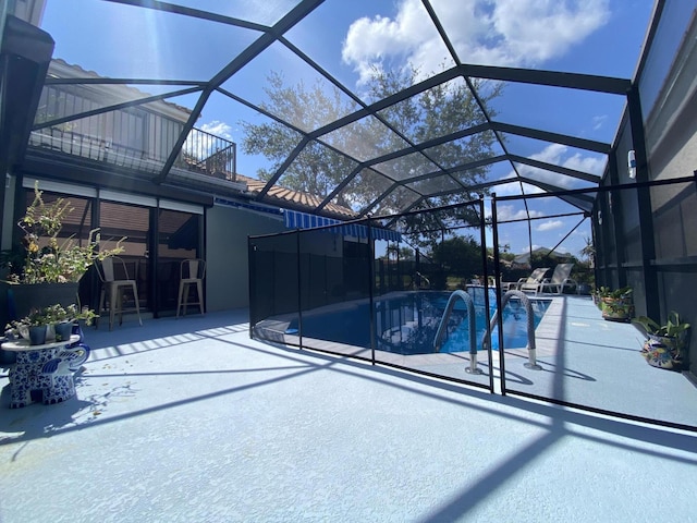 outdoor pool featuring a patio and glass enclosure