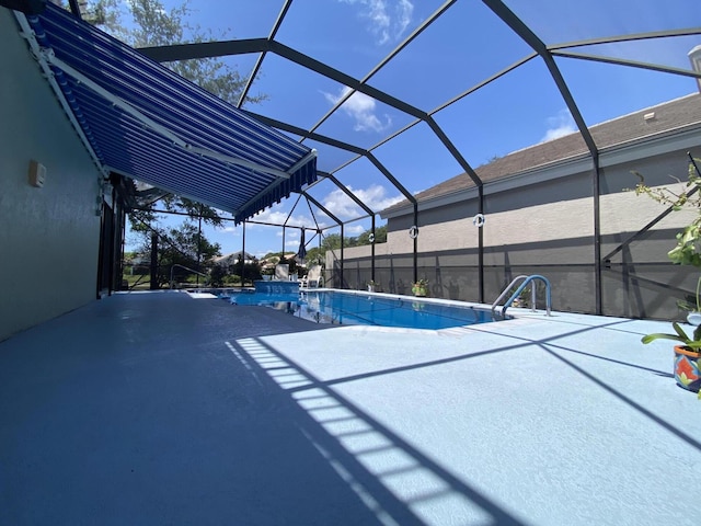 swimming pool with a patio area and glass enclosure