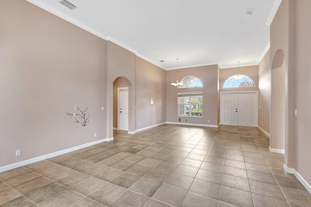 3588 Turtle Island Ct, West Palm Beach, FL 33411 - unfurnished room featuring arched walkways, baseboards, crown molding, a chandelier, and a towering ceiling