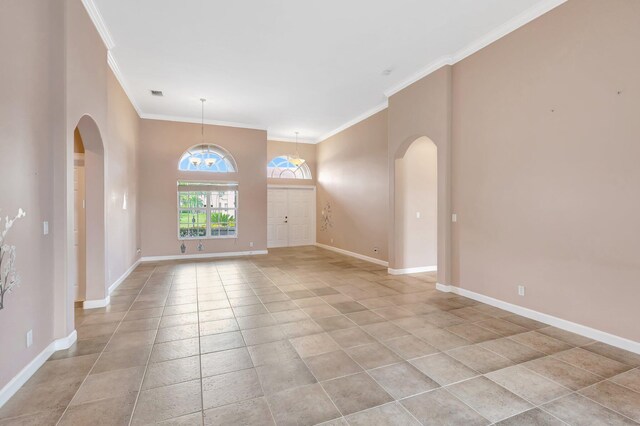 3588 Turtle Island Ct, West Palm Beach, FL 33411 - spare room with arched walkways, ornamental molding, baseboards, and light tile patterned flooring