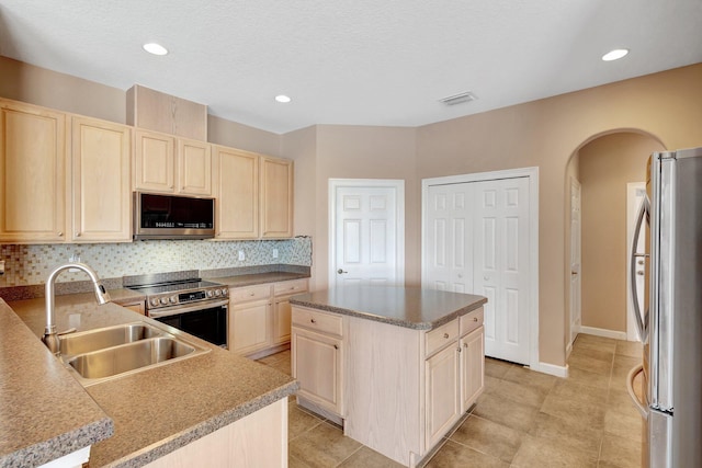 3588 Turtle Island Ct, West Palm Beach, FL 33411 - kitchen with stainless steel appliances, light brown cabinets, arched walkways, a sink, and decorative backsplash