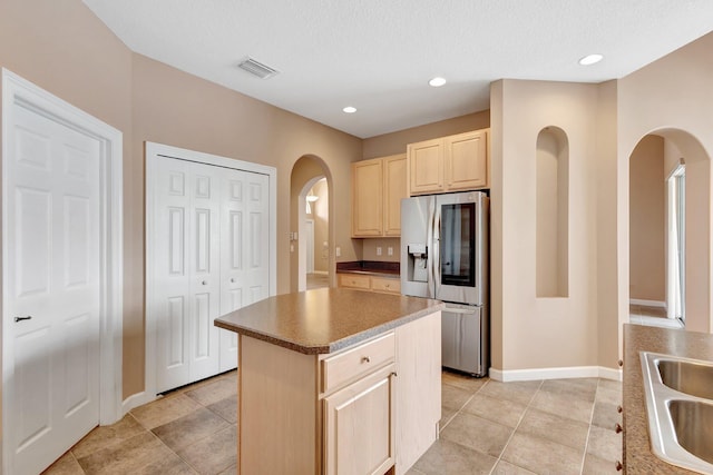 3588 Turtle Island Ct, West Palm Beach, FL 33411 - kitchen with stainless steel fridge, light brown cabinets, arched walkways, baseboards, and a textured ceiling