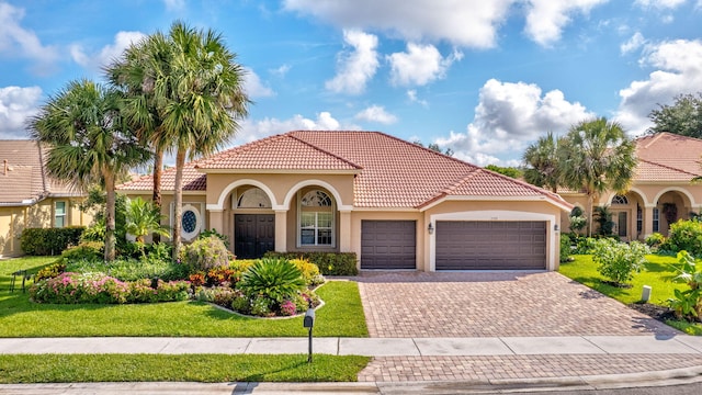 3588 Turtle Island Ct, West Palm Beach, FL 33411 - mediterranean / spanish-style home with stucco siding, a garage, decorative driveway, and a front lawn