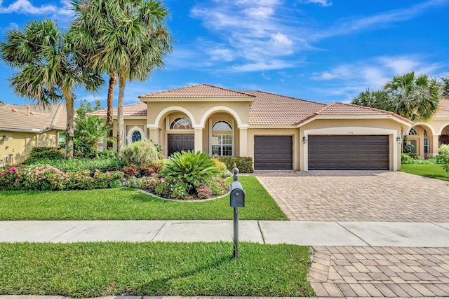 3588 Turtle Island Ct, West Palm Beach, FL 33411 - mediterranean / spanish-style house featuring a garage, a tiled roof, decorative driveway, and stucco siding