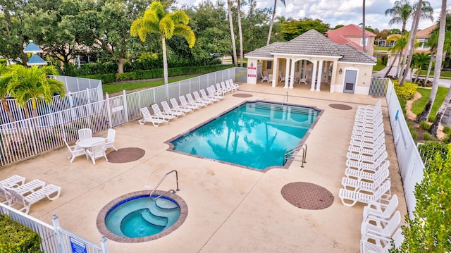 3588 Turtle Island Ct, West Palm Beach, FL 33411 - community pool featuring a patio area, a hot tub, fence, and an outbuilding