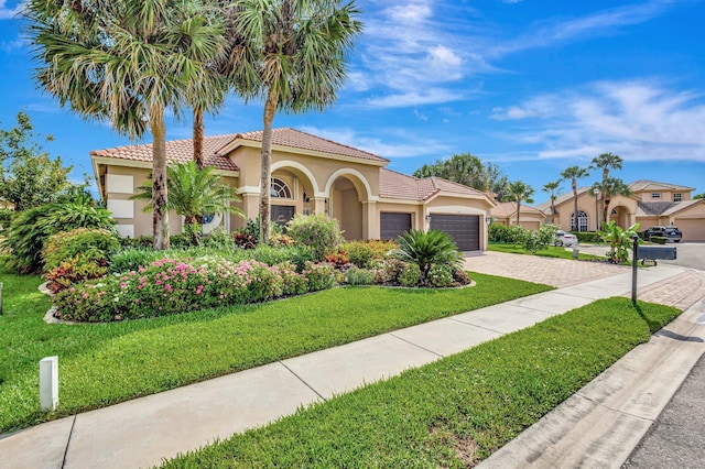 3588 Turtle Island Ct, West Palm Beach, FL 33411 - mediterranean / spanish home featuring stucco siding, a tiled roof, a garage, driveway, and a front lawn
