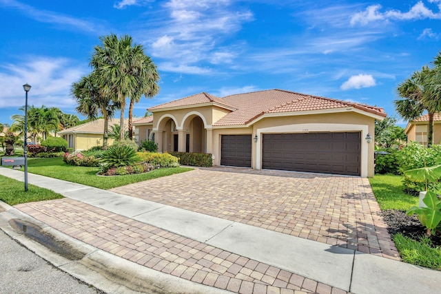 3588 Turtle Island Ct, West Palm Beach, FL 33411 - mediterranean / spanish-style house with an attached garage, stucco siding, decorative driveway, a front lawn, and a tile roof