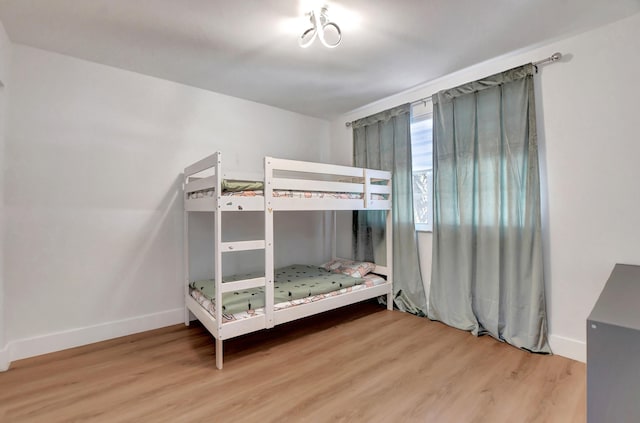 bedroom featuring wood finished floors and baseboards