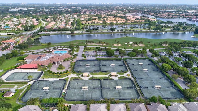 aerial view of property's location featuring a large body of water, nearby suburban area, and a golf course