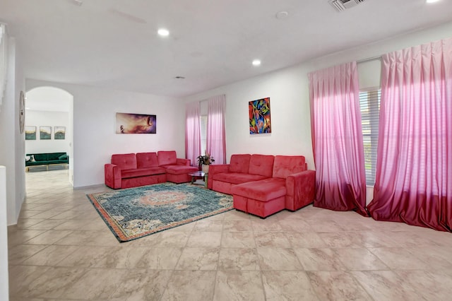 living room with arched walkways, plenty of natural light, and recessed lighting