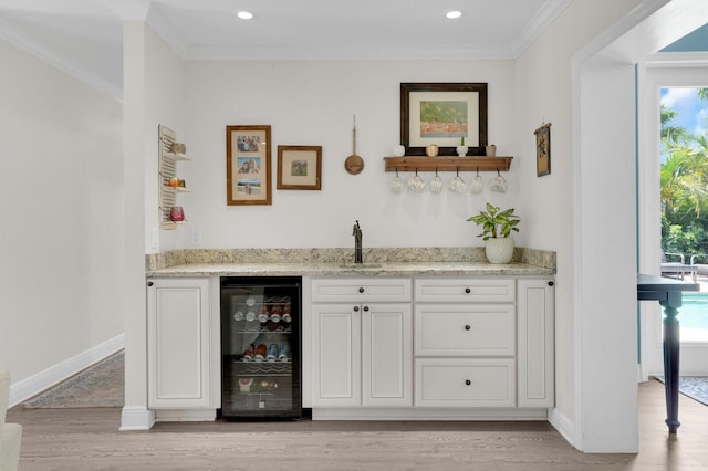 765 Lagoon Dr, North Palm Beach, FL 33408 - indoor wet bar featuring wine cooler, ornamental molding, light wood-style flooring, baseboards, and recessed lighting