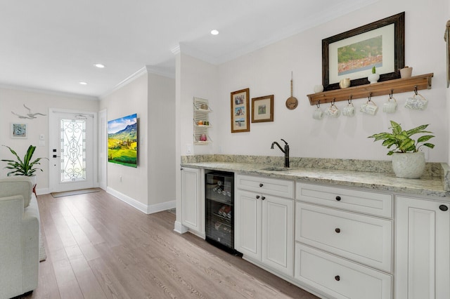 765 Lagoon Dr, North Palm Beach, FL 33408 - indoor wet bar with wine cooler, crown molding, baseboards, light wood finished floors, and recessed lighting