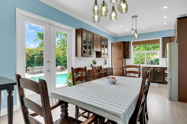 765 Lagoon Dr, North Palm Beach, FL 33408 - dining area featuring light wood-style flooring, a chandelier, ornamental molding, recessed lighting, and french doors