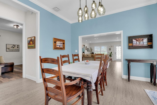 765 Lagoon Dr, North Palm Beach, FL 33408 - dining area with light wood-style floors, baseboards, and ornamental molding