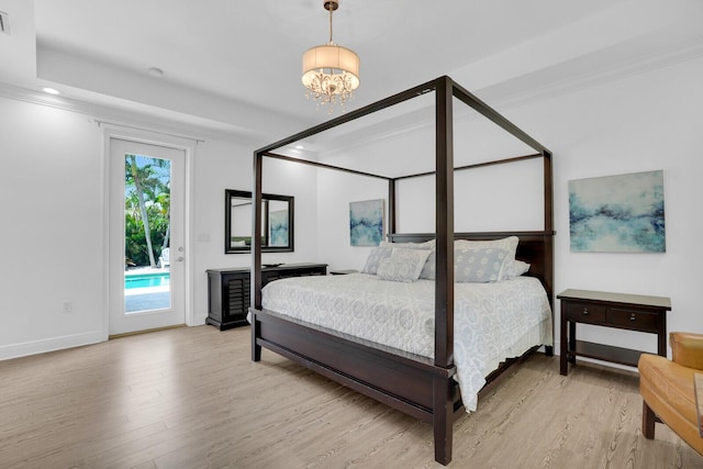 765 Lagoon Dr, North Palm Beach, FL 33408 - bedroom with light wood-style floors, access to outside, a chandelier, ornamental molding, and baseboards