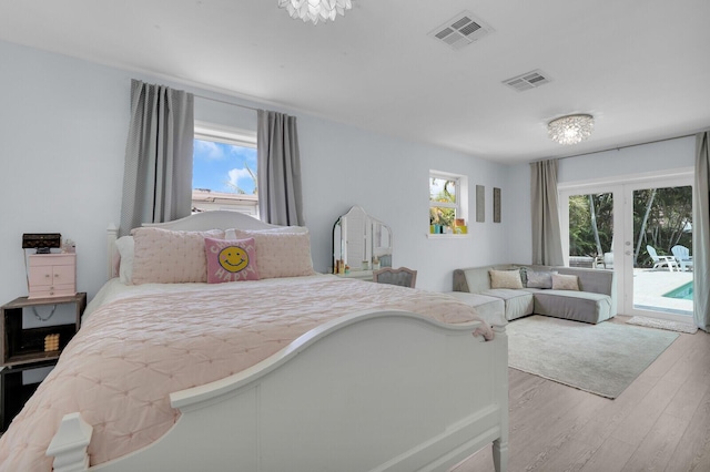 765 Lagoon Dr, North Palm Beach, FL 33408 - bedroom with access to exterior, multiple windows, wood finished floors, and french doors