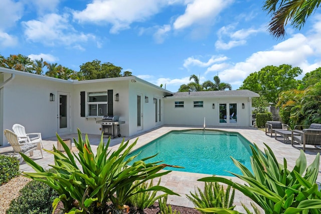 765 Lagoon Dr, North Palm Beach, FL 33408 - outdoor pool with french doors, a patio area, grilling area, and fence