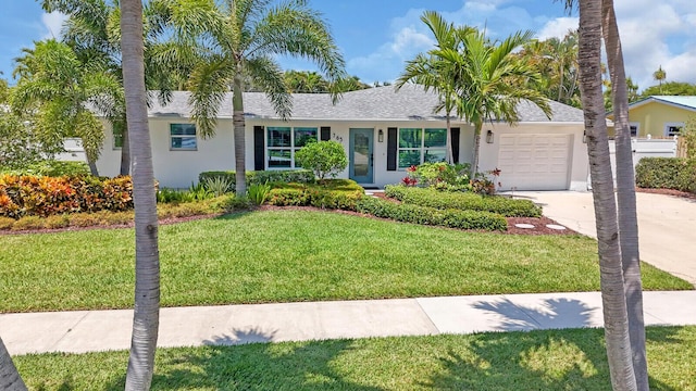 765 Lagoon Dr, North Palm Beach, FL 33408 - single story home with an attached garage, driveway, stucco siding, and a front yard