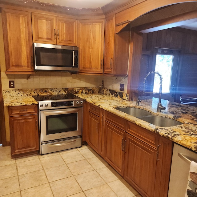 16761 130th Way N, Jupiter, FL 33478 - kitchen with appliances with stainless steel finishes, brown cabinetry, and light stone counters