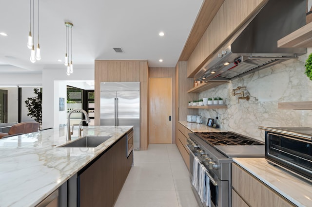 160 Periwinkle Dr, Hypoluxo, FL 33462 - kitchen with high end appliances, a sink, wall chimney range hood, modern cabinets, and recessed lighting