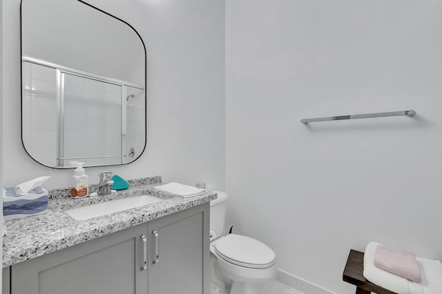 full bath with toilet, baseboards, vanity, and an enclosed shower