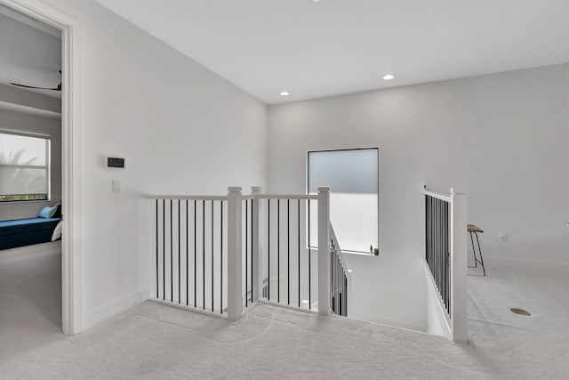 hall with an upstairs landing, carpet, baseboards, and recessed lighting