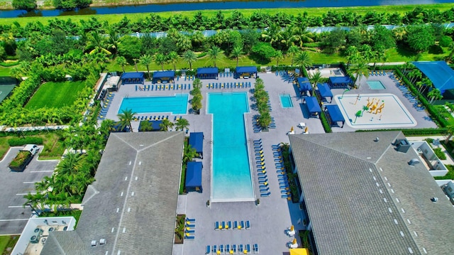 drone / aerial view of a pool area and a nearby body of water
