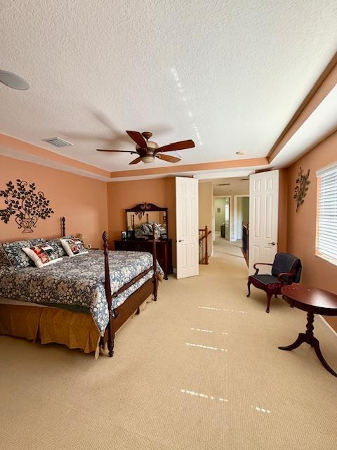 bedroom featuring light colored carpet and a textured ceiling
