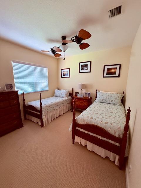 bedroom with light colored carpet and a ceiling fan