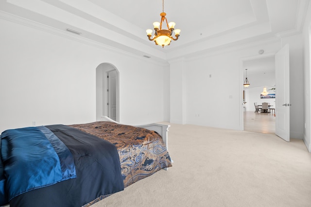 bedroom with a chandelier, a tray ceiling, arched walkways, light carpet, and ornamental molding