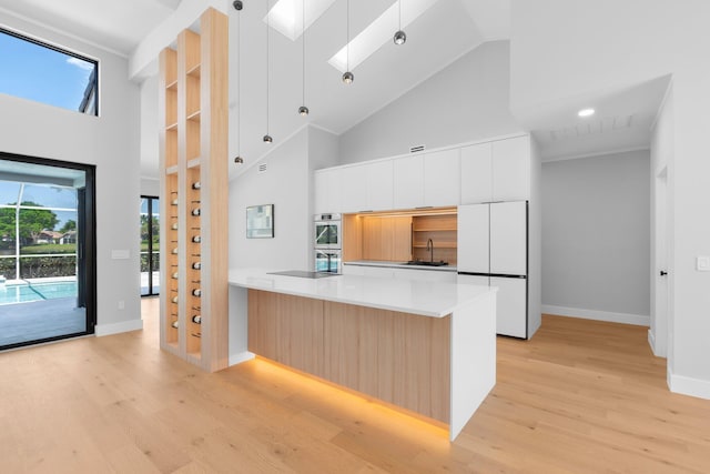 17726 Litten Dr, Boca Raton, FL 33498 - kitchen with modern cabinets, freestanding refrigerator, high vaulted ceiling, light wood-style flooring, and double oven