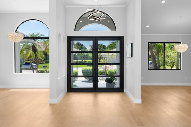 17726 Litten Dr, Boca Raton, FL 33498 - foyer entrance featuring wood finished floors, french doors, a chandelier, healthy amount of natural light, and ornamental molding