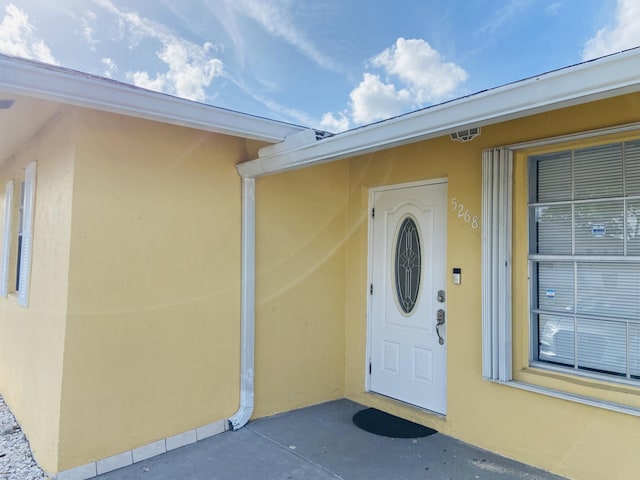 entrance to property featuring stucco siding