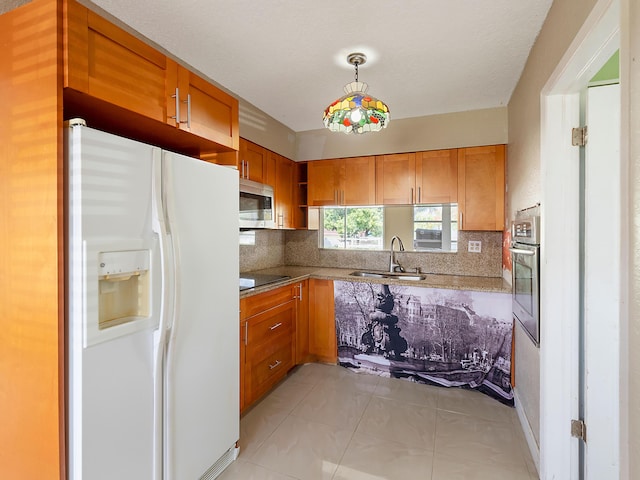 1421 E River Dr, Margate, FL 33063 - kitchen featuring appliances with stainless steel finishes, a sink, brown cabinetry, and backsplash
