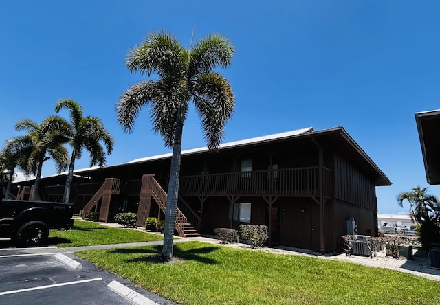 500 N Francisco St Unit 211, Clewiston, FL 33440 - view of property featuring uncovered parking, stairs, and central AC unit