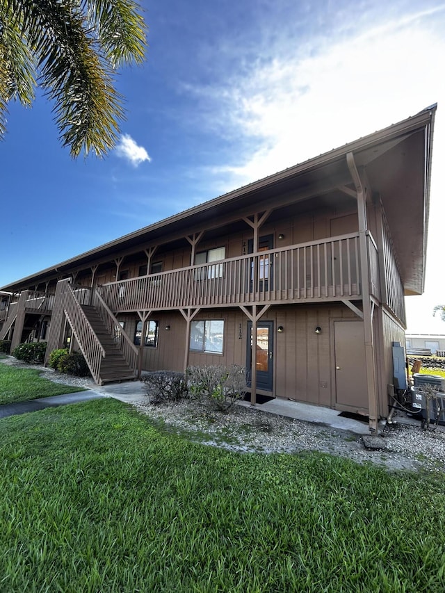 500 N Francisco St Unit 211, Clewiston, FL 33440 - rear view of property featuring a lawn and stairs
