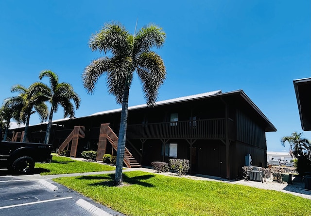 500 N Francisco St Unit 211, Clewiston, FL 33440 - view of building exterior with stairway, cooling unit, and uncovered parking