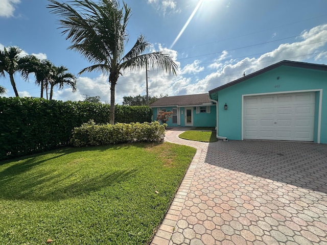 442 Griswold Dr, Lake Worth Beach, FL 33461 - ranch-style house featuring stucco siding, a garage, a front yard, and decorative driveway